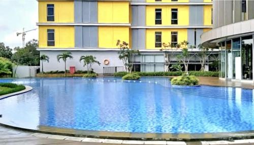 a large swimming pool in front of a building at Apt Pejaten Park Biru 2 BR with Swim Pool, Bathub and Wi-Fi in Jakarta