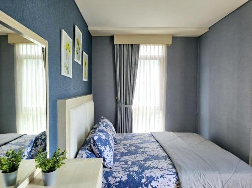 um quarto com 2 camas com paredes e janelas azuis em Apt Pejaten Park Biru 2 BR with Swim Pool, Bathub and Wi-Fi em Jakarta