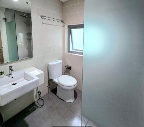 uma casa de banho com um WC branco e um lavatório. em Apt Pejaten Park Biru 2 BR with Swim Pool, Bathub and Wi-Fi em Jakarta