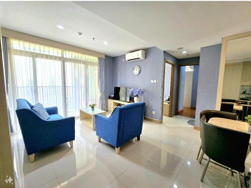 a living room with two blue chairs and a table at Apt Pejaten Park Biru 2 BR with Swim Pool, Bathub and Wi-Fi in Jakarta