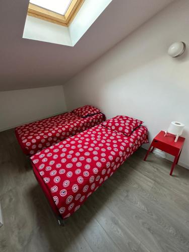 a red bed in a room with a window at PEH ancienne version in Bagnolet