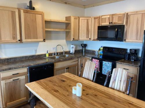 a kitchen with wooden cabinets and a wooden table at Keweenaw Waters Resort in Houghton