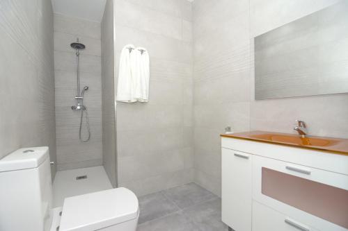 Un baño blanco con inodoro y lavabo. en Bam ! Centro ! Centre ! Zentrum !, en Valencia