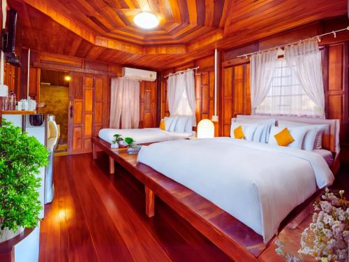a bedroom with two beds and a wooden ceiling at SCN Resort and Spa Rayong in Ban Chang