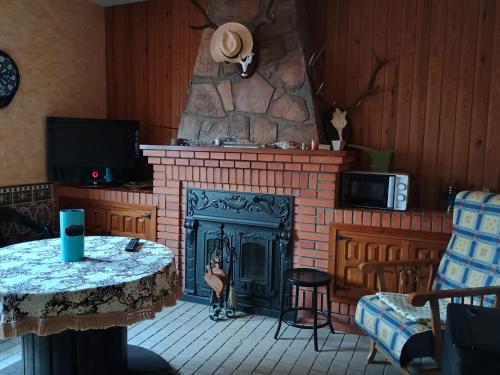 a living room with a fireplace and a table at Casa rural el Retiro de Sancho in Cózar