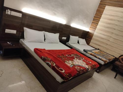 a bedroom with two beds with a red blanket at 4N Homestay in Amritsar