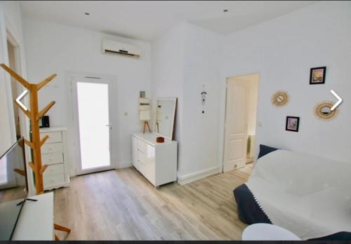 Cette chambre blanche comprend un lit, une commode et un miroir. dans l'établissement Nice libération, à Nice