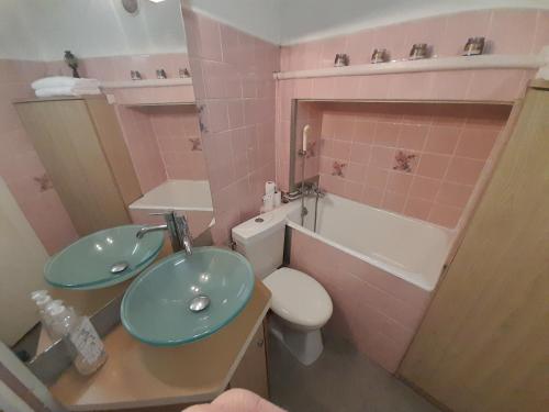 a pink bathroom with a sink and a toilet at La Flûte 2 in Thiers