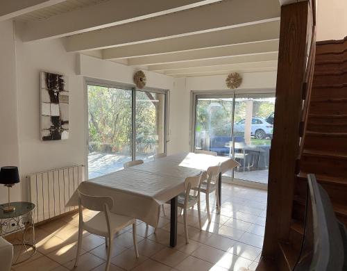 une salle à manger avec une table et des chaises blanches dans l'établissement Villa familiale carlex, à Sète