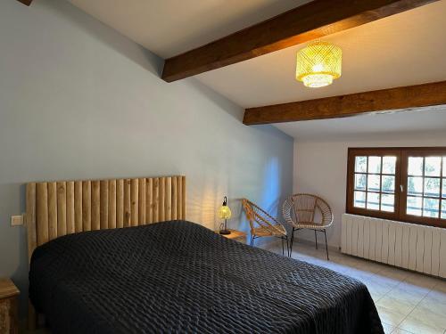 1 dormitorio con 1 cama negra y 1 silla en Villa familiale carlex, en Sète