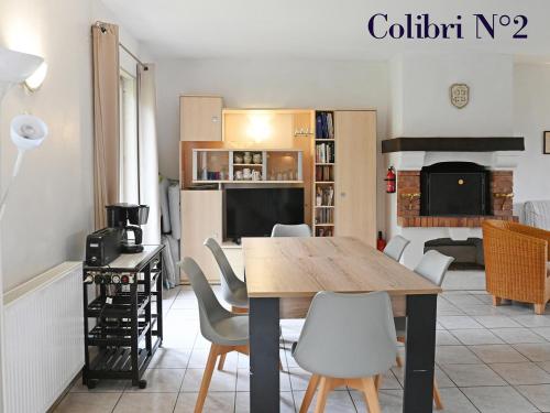 une salle à manger avec une table et des chaises dans l'établissement Le colibri, à Étretat