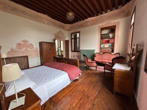 a bedroom with a bed and a chair and a couch at LA GASTALDIA in Pontecasale