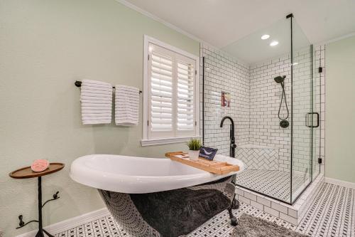 a white bathroom with a tub and a shower at Expansive Texarkana Home with Yard Near Golf! in Texarkana