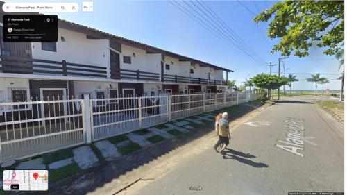 una persona caminando por una calle al lado de un edificio en Casa em frente ao mar - Condominio, en Caraguatatuba