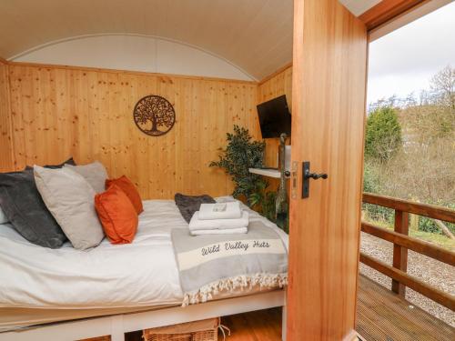 a bed in a room with a balcony at Red Kite at Wild Valley Huts in Oswestry