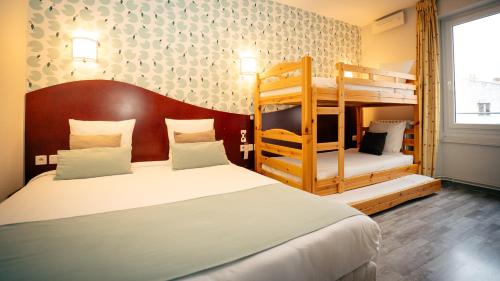 Hotel les Commercants في كليرمون فيران: غرفة نوم بسريرين بطابقين وسلم