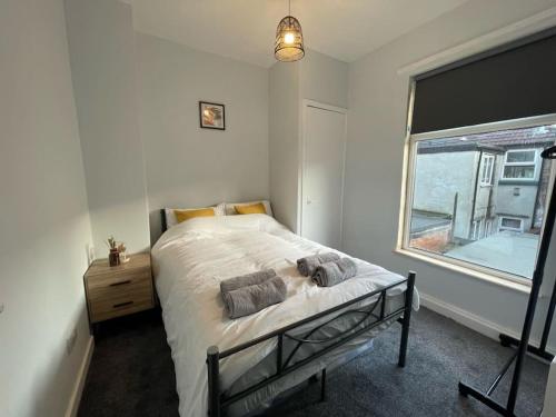een witte slaapkamer met een bed en een raam bij Entire Modern House Close to 2 Stadiums & Town Centre in Liverpool