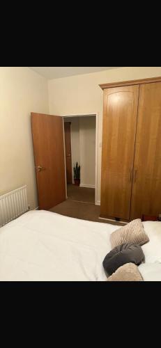 ダブリンにあるDouble Room in a Cozy Apartment Dublin City Centreのベッドルーム1室(ベッド1台付)、木製キャビネットが備わります。