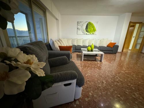 a living room with a couch and a table at Apto. Cullera vistas espectaculares primera línea in Cullera