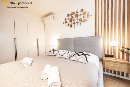 a bedroom with a large bed with towels on it at Baltic Apartments - Kormoran in Świnoujście