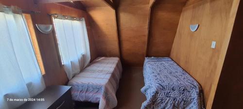ein kleines Zimmer mit 2 Betten und einem Fenster in der Unterkunft Fortunata del Beagle in Puerto Williams