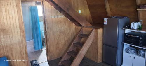 eine kleine Küche mit einer Treppe in einem winzigen Haus in der Unterkunft Fortunata del Beagle in Puerto Williams