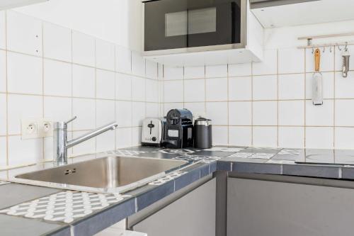 eine Küche mit einer Spüle und einer Kaffeemaschine auf der Theke in der Unterkunft Cosy Apartment 4P 1BDR Clichy proche Paris in Clichy