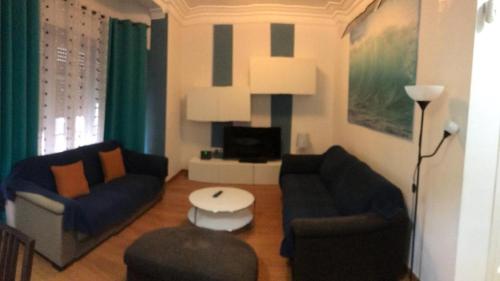 uma sala de estar com dois sofás e uma televisão em Apartamentos Turia em Valência