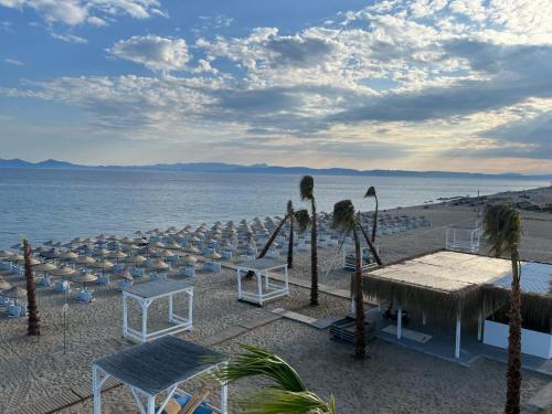 un grupo de sillas y mesas en una playa en Yade Apart Pension en Ayvalık