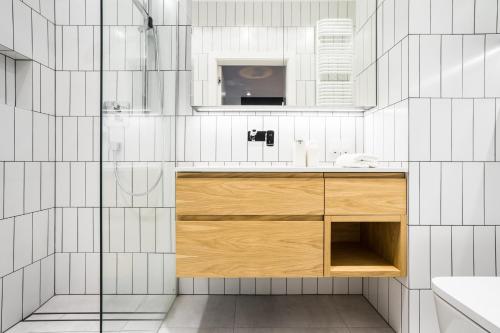 łazienka z umywalką i drewnianą szafką w obiekcie VipWarsawApartments Amber Mennica Residence w Warszawie