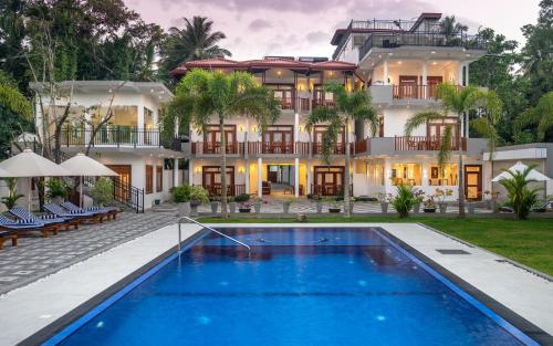a hotel with a swimming pool in front of a building at Hotel Southern Blue Sapphire in Induruwa