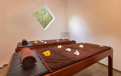 a room with two beds with towels and flowers on them at Hotel Southern Blue Sapphire in Induruwa