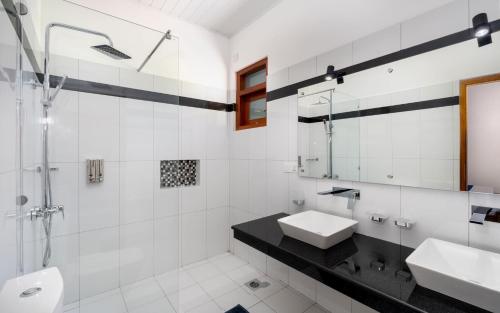 a white bathroom with two sinks and a mirror at Hotel Southern Blue Sapphire in Induruwa