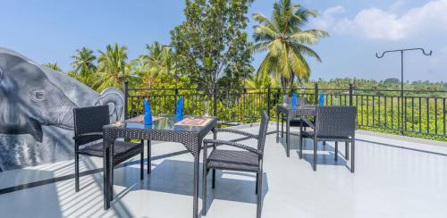 a patio with tables and chairs and an elephant statue at Hotel Southern Blue Sapphire in Induruwa