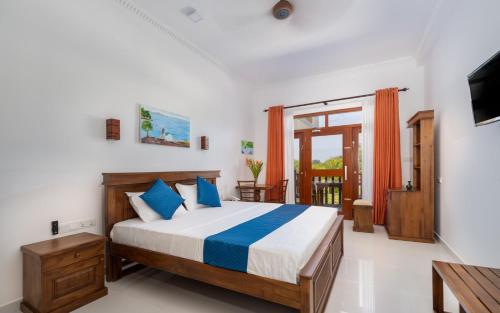 a bedroom with a bed and a television in it at Hotel Southern Blue Sapphire in Induruwa