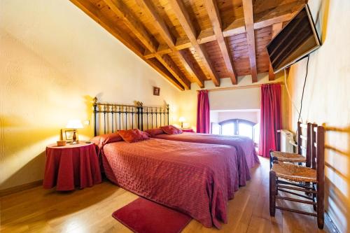 a bedroom with a bed with a red bedspread at Posada El Aprisco Manjirón in Manjirón