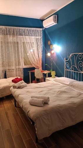 two beds in a bedroom with a blue wall at Colombo Holidays APT in Rome