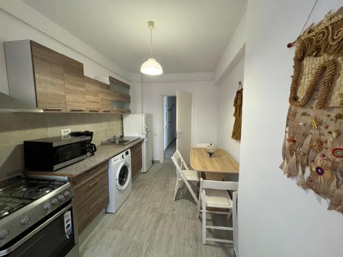 a kitchen with a table and a dining room at Apartament in bloc rezidential in Iaşi