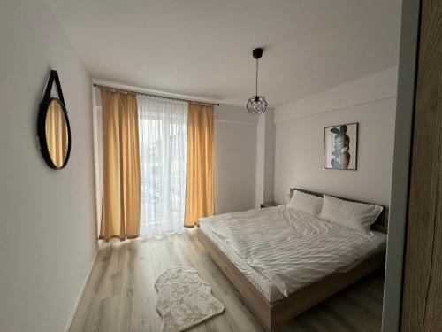 a bedroom with a bed and a large window at Apartament in bloc rezidential in Iaşi