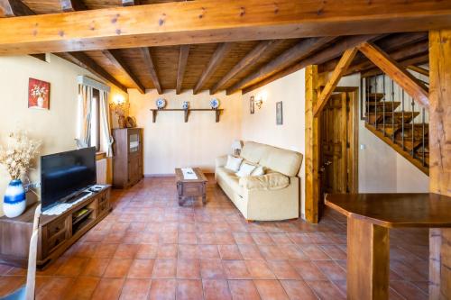 a living room with a couch and a tv at Posada El Aprisco Manjirón in Manjirón