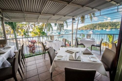 a restaurant with tables and chairs and a view of the water at Seaside Studio: Cruz Bay Gem in Enighed