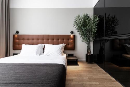 um quarto com uma cama grande e uma planta em The Modernist Thessaloniki em Tessalônica