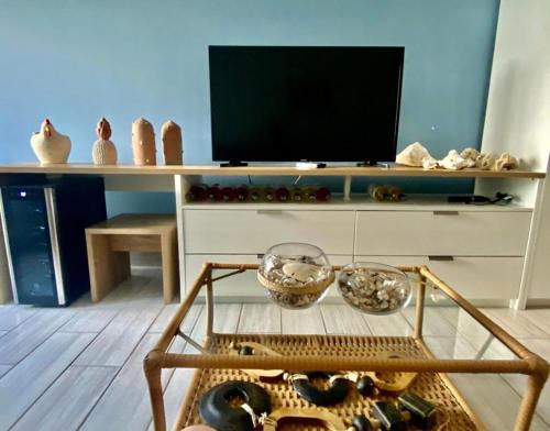 sala de estar con TV y mesa en Polinesia Resort - Porto de Galinhas - Apartamentos com somente 1 opção de Térreo com Piscina Privativa - Acesso ao Hotel Samoa, en Porto de Galinhas