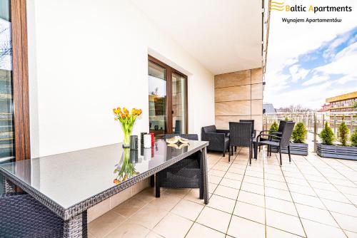 a balcony with a table and chairs on a building at Baltic Apartments - Kormoran in Świnoujście
