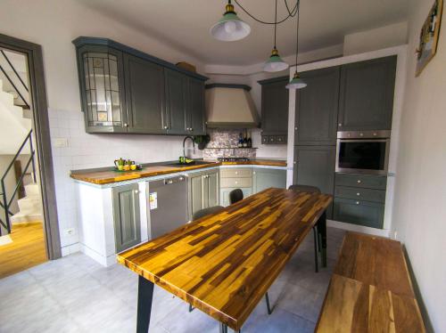 a kitchen with green cabinets and a wooden table at La casetta del prato in Iesi