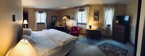 a bedroom with a bed and a desk and a television at Colorado Bed & Breakfast with beautiful views in Evergreen