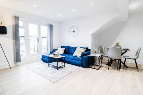 a living room with a blue couch and a table at Modern 1-Bed Apartment in Buckinghamshire with Free WiFi, Parking & Garden in Buckinghamshire