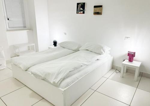 a white bed in a white room with a white floor at Casita1906 in Rocchetta a Volturno