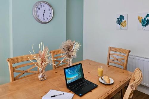 a laptop computer sitting on a wooden table at Cosy yet spacious, 3BR, Parking, Village Location in Oswestry