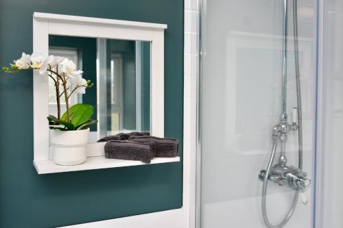 a bathroom with a mirror and a shelf with towels at Village Life, cosy yet spacious home in Oswestry